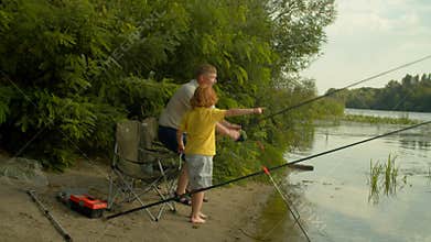 Joyful family of fishermen with spin fishing rod catching fish on river