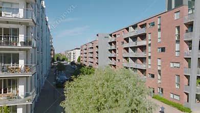 Modern residential urban borough in city. Multistory apartment buildings along street with parked cars. Copenhagen