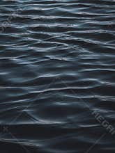 Waves backlit by the light of the setting sun. Transparent. Navy blue. Blue. Background.