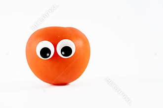 sun ripened tomato with cartoon rolling googly eyes isolated on white background