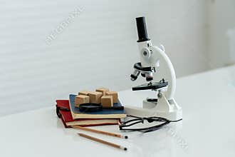 Stationery with books, pencils, glasses, magnifying glass, microscope Wooden blocks on the laboratory table. equipment used for