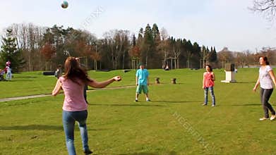 Teenagers play volleyball in park on grass in Germany