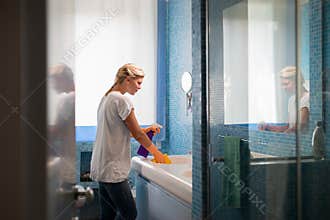 Woman doing chores and cleaning bathroom at home