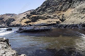 oil spills on the beaches of the pacific ocean with contaminated rocks of repsol company in lima peru in the year 2022