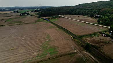 Flying over an passenger train on single track through Swedish landscape