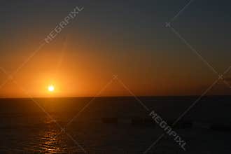 Vibrant Ocean Sunset with Fiery Orange Sky and Clouds