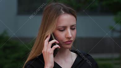 Angry and agressive woman screams and talks on the phone, curses and quarrels in rage outdoor urban city. Yelling at the