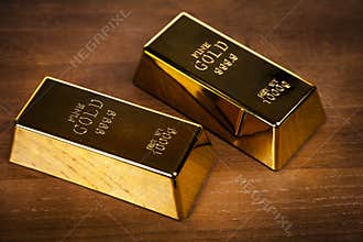 Two gold bars on wooden background