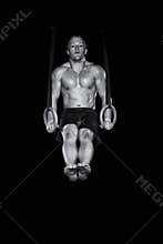 Strong gymnast works on the rings