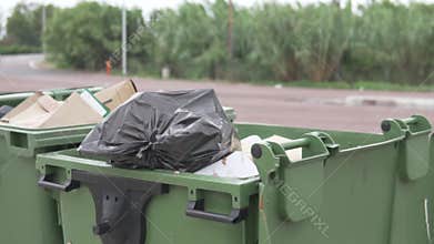 Two large garbage cans stand on the highway in Spain in the summer