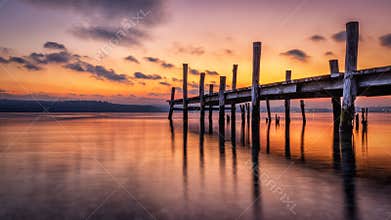 Scenic view of a pier on the sea at golden sunset