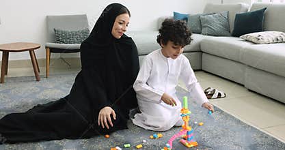 Loving Islamic mother in traditional hijab spend time with son