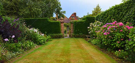 Colorful garden with gate and hedges
