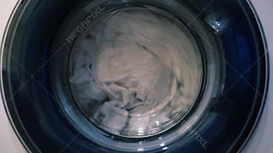 The movement of laundry when drying in the washing machine. Wet things in the drum of the washing machine.