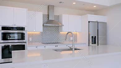 Stunning kitchen interior in new luxurious house with empty stone countertop and integrated sink. White glossy cabinetry