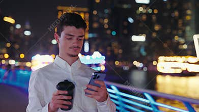 Attractive Young Guy Texting in Social Networks Standing in the Street. Man in Casual Outfit Using his Smartphone