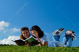 Two girls reading books outside
