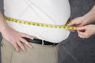 Hands Measuring Abdomen Of Obese Man
