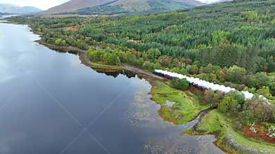 Steam Train in Scotland Passing By a Loch on the Famous Film Route