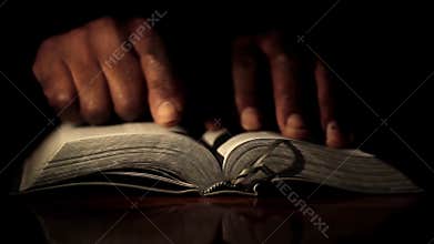 Praying with hand on bible with black background stock photo