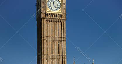 Red London buses crossing in front of Big Ben, Houses of Parliament in a blue sky, summer, London, England