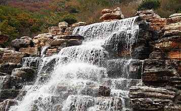 Waterfalls flow in the charming autumn mountains