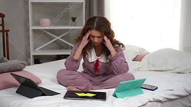 Overburdened exhausted mature woman closing laptop sighing holding head in hands. Wide shot portrait of tired overworked