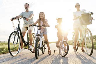 Family of four caucasian people sitting on bikes
