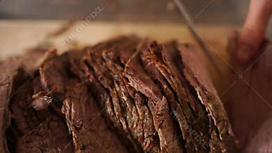 Cook sliced the roast beef and put the knife on the cutting board