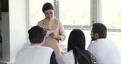 Young smiling Indian waitress in apron take order