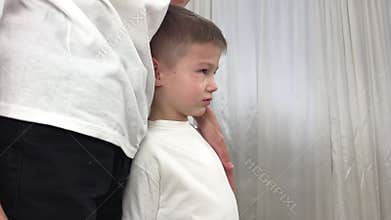 children communicate little boy stands next to brother clinging to him he is sad rubbing nose eyes he is offended does