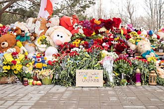 Toys and flowers lie at a trolleybus stop next to a house blown up by a Russian rocket on Pobeda in the city of Dnepr in Ukraine