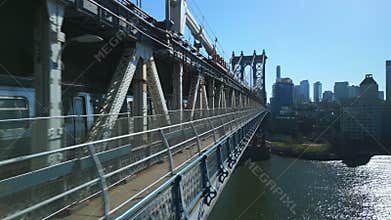 Tracking of subway train passing Manhattan Bridge and heading to Brooklyn. Tight fly along bridge deck. New York City
