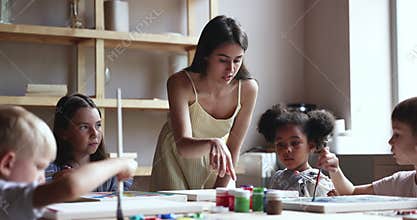 Young female artist lead art class for pretty little kids