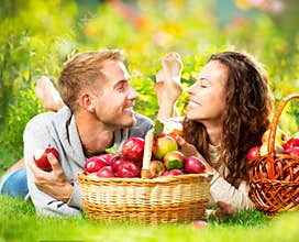 Couple Relaxing on the Grass and Eating Apples