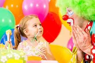 Happy child girl with clown on birthday party
