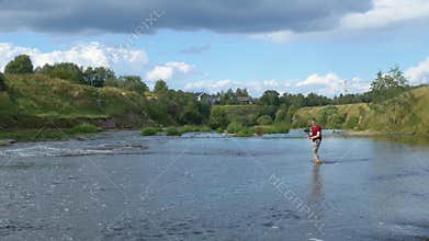 Videographer walks on the water and films.