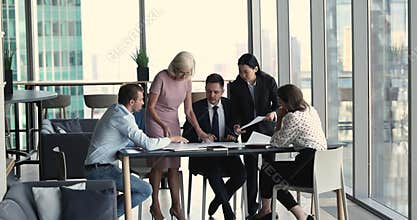 Diverse employees giving documents to boss for signing