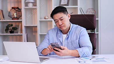 Bored, sad, exhausted asian male office worker showing no interest in work.