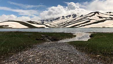 mountain lakes where snow water accumulates, magnificent zebra-patterned mountains and clouds that herald precipitation