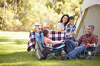 Family Enjoying Camping Holiday In Countryside