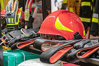 Firefighter equipment arrangement in a work area Red and black firefighting gloves, helmets, protective eyeweargoggles on shelves