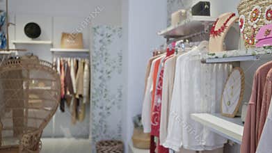 Clothing shop interior featuring blurred garments and accessories with bright decor in stylish boutique setting