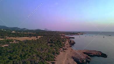 Old defense tower on cliff in Ibiza at sunset. Unique aerial view flight drone