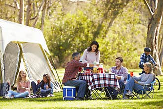 Two Families Enjoying Camping Holiday In Countryside