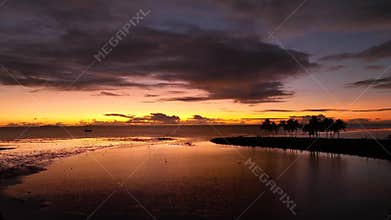 Silhouette of a yacht against the backdrop of a colorful tropical sunset sky at the sea and Fiji Island