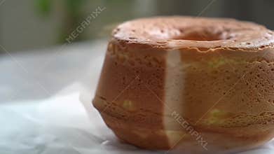 Delicious Japanese Chiffon Cake Showcase Its Golden Crust and Airy Texture on Table with a White Parchment Background Its A