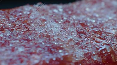 Extreme Close-Up: Sparkling Sugar Crystals on a Red Gummy Candy Surface