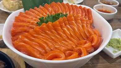 Close-up of fresh raw salmon sashimi slices on a traditional Japanese platter.