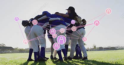 Huddling before game seven softball players holding gloves linking arms on field, with pink network